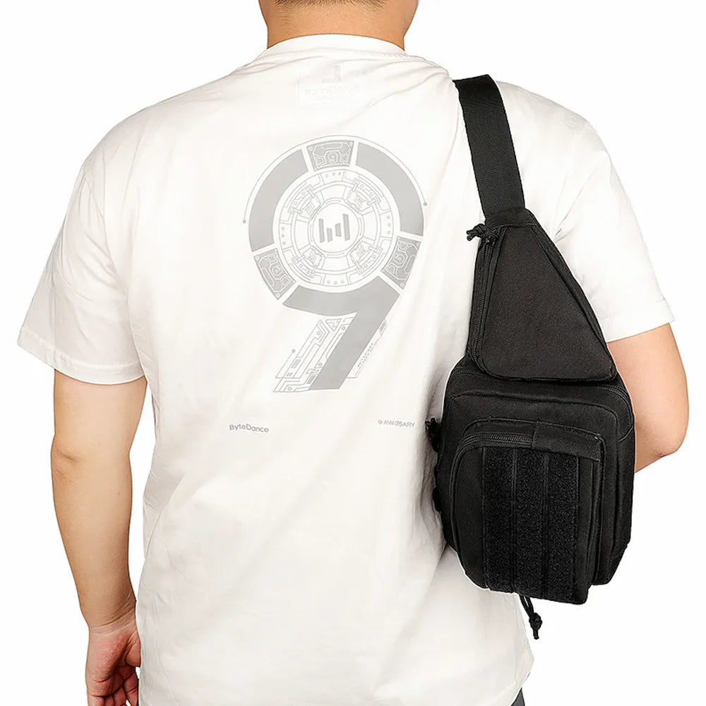Back view of a man carrying a black tactical pack on his shoulder